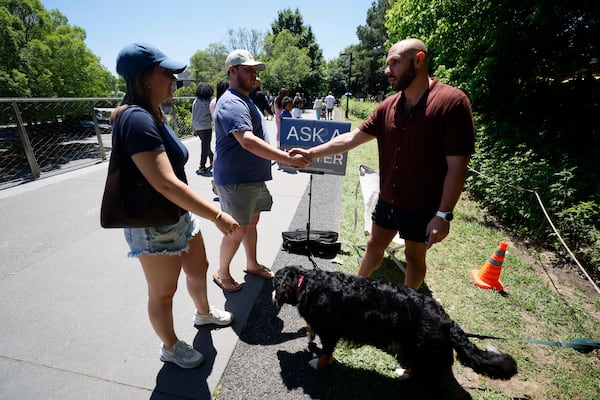 Marietta couple Joey Kostigen and Katie Dennard stop along the Beltline to speak with attorney Cody Randall after seeing his content on TikTok. (Miguel Martinez/AJC)