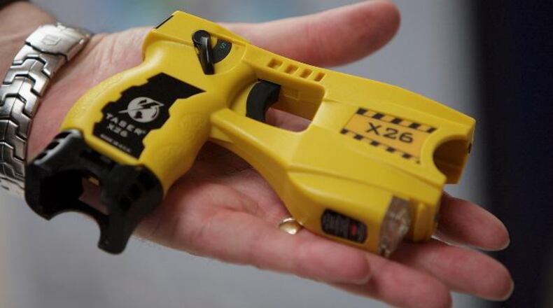 A representative from Taser International shows the companies latest X26 stun gun during the Police Federation Conference at Winter Gardens on May 16, 2007, in Blackpool, England. (Photo by Christopher Furlong/Getty Images)