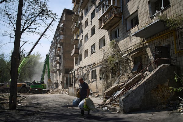 An elderly man carries belongings from his apartment that was destroyed by Russia's missile attack on Tuesday, in Kyiv, Ukraine, Wednesday, June 18, 2025.(AP Photo/Efrem Lukatsky)