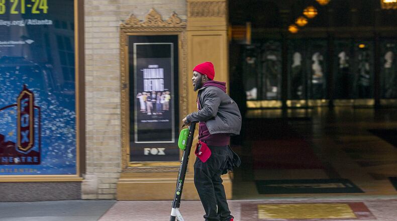 A man rides a Lime Scooter along Peachtree Street in Atlanta’s Midtown community, Friday, Jan. 4, 2019.