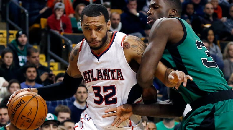 Atlanta Hawks forward Mike Scott (32) drives against Boston Celtics forward Brandon Bass (30) during the first half of an NBA basketball game in Boston, Wednesday, Jan. 14, 2015. (AP Photo/Elise Amendola)