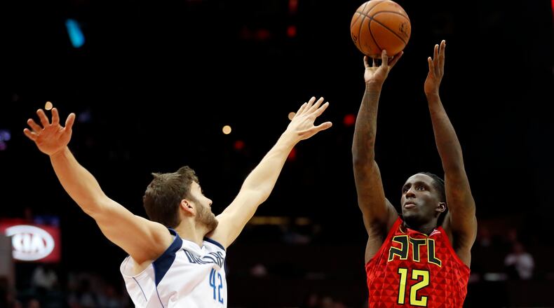 Atlanta Hawks' Taurean Prince, right, shoots against Dallas Mavericks' Maximilian Kleber, of Germany, in the first quarter of an NBA basketball game in Atlanta, Saturday, Dec. 23, 2017. (AP Photo/David Goldman)