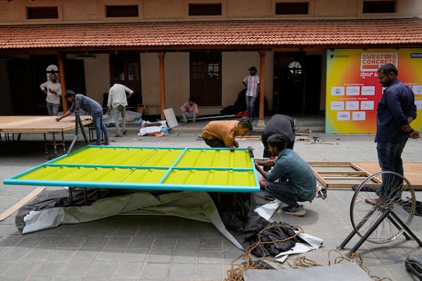 Workers assemble Neralu, an innovative portable heat shelter, before installing it at the Sweat and Concrete 2025 event in Bengaluru, India, Wednesday, May 28, 2025. (AP Photo/Aijaz Rahi)