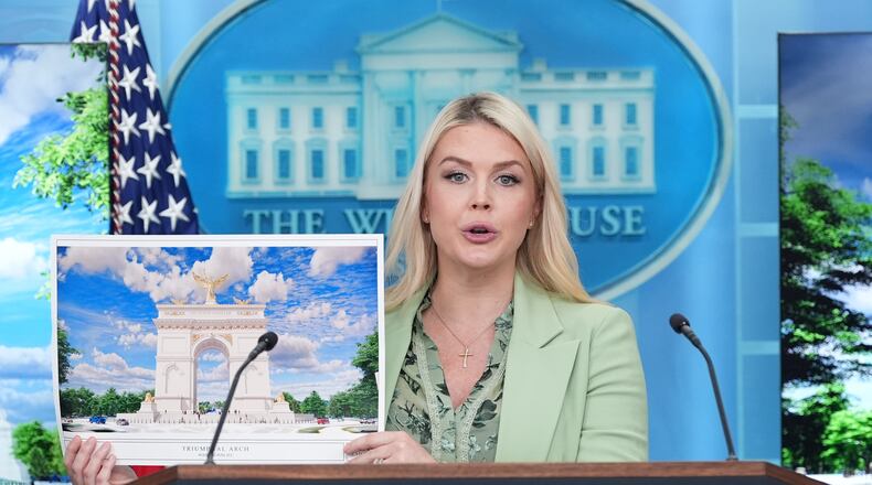 White House press secretary Karoline Leavitt holds up an artist rendering of the new triumphal arch as she speaks with reporters in the James Brady Press Briefing Room at the White House, Wednesday, April 15, 2026, in Washington. (AP Photo/Alex Brandon)