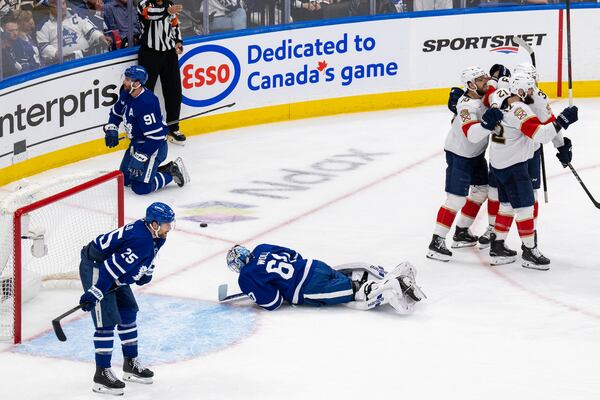 Florida Panthers left wing Jonah Gadjovich (12) celebrates after his goal with teammates as Toronto Maple Leafs goaltender Joseph Woll (60) and others look on during the second period of Game 7 of a second-round NHL hockey playoff series in Toronto, Sunday, May 18, 2025. (Chris Young/The Canadian Press via AP)