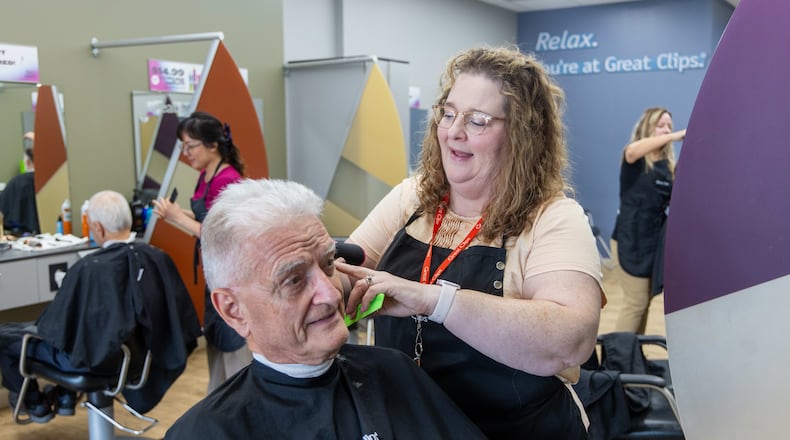 Salon Manager Susan Perdue (right), at Great Clips in Cumming, talks with Richard Herrmann as she cuts his hair. Perdue, who was born deaf, communicates with her clients by reading their lips in the mirror as she stands behind them styling their hair. PHIL SKINNER FOR THE ATLANTA JOURNAL-CONSTITUTION