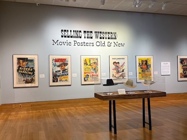 More than four dozen posters for Hollywood Westerns are ordered chronologically between the early 1900s and modern day in new exhibition at Booth Western Art Museum. (Danielle Charbonneau/AJC)