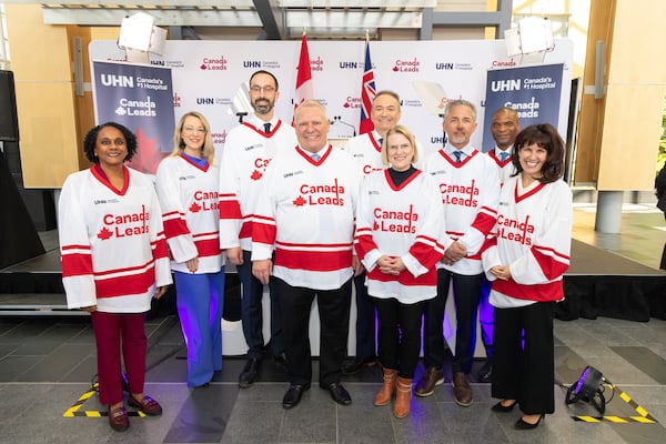 In this photo provided by the University Health Network, Ontario Premier Doug Ford, center, stands with other government and UHN officials in custom hockey jerseys during the announcement of the "Canada Leads" program in Toronto on Monday, April 7, 2025. (Jacob Cote/UHN via AP)