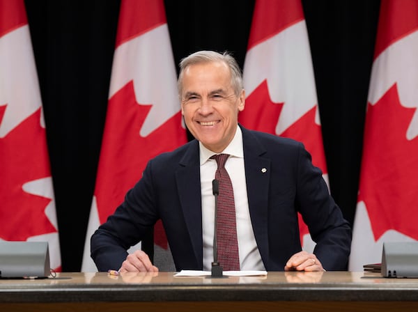 Prime Minister Mark Carney smiles as he takes his seat at his first news conference since winning the federal election, in Ottawa, Friday, May 2, 2025. (Adrian Wyld /The Canadian Press via AP)