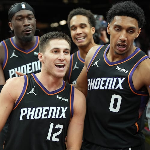 Phoenix Suns guard Collin Gillespie (12) celebrates with teammates after hitting the winning shot against the Minnesota Timberwolves during the second half of an NBA Cup basketball game, Friday, Nov. 21, 2025, in Phoenix. (AP Photo/Rick Scuteri)