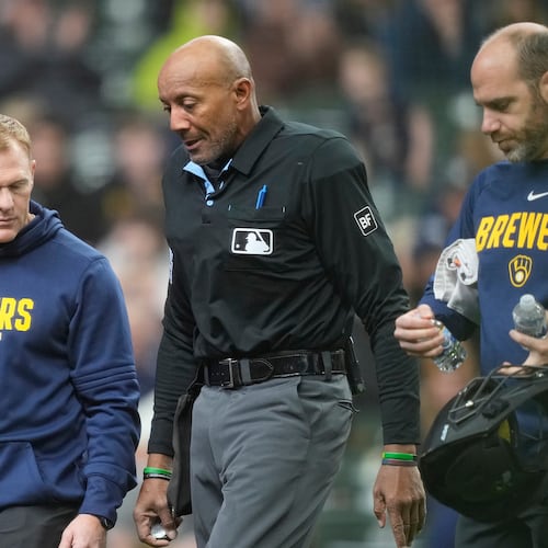 Major League Baseball umpire CB Bucknor, center, exits the game after being hit by a foul ball during the second inning of a baseball game between the Milwaukee Brewers and the Tampa Bay Rays, Wednesday, April 1, 2026, in Milwaukee. (AP Photo/Kayla Wolf)