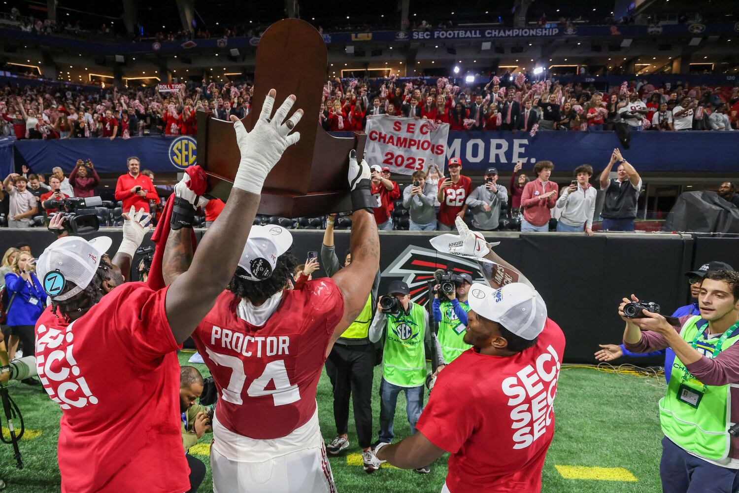 Alabama Crimson Tide players including offensive lineman Kadyn Proctor (74) celebrate after defeating the Georgia Bulldogs 27-24 in the SEC Championship football game at the Mercedes-Benz Stadium in Atlanta, on Saturday, December 2, 2023. (Jason Getz / Jason.Getz@ajc.com)