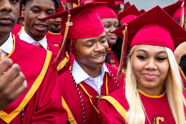 James Sims (center) smiles with other members of Creekside High School’s Tribe Academy before a group photo at their graduation ceremony at Gateway Arena in College Park on Thursday, May 18, 2023. (Arvin Temkar/AJC)