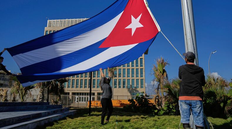 Workers fly the Cuban flag at half-mast at the Anti-Imperialist Tribune near the U.S. embassy in Havana, Cuba, Monday, Jan. 5, 2026, in memory of Cubans who died two days before in Caracas, Venezuela during the capture of Venezuelan President Nicolas Maduro by U.S. forces. (AP Photo/Ramon Espinosa)