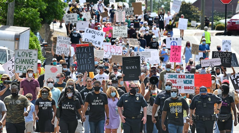 JPastor Lee Jenkins (center left) with wife Martica, Congresswoman Lucy McBath (center), and Roswell Police Chief James Conroy (center right) joined the peaceful Solidarity March in downtown Roswell on June 13, 2020. Pastor Jenkins organized the march to protest racism and police brutality. HYOSUB SHIN / HYOSUB.SHIN@AJC.COM