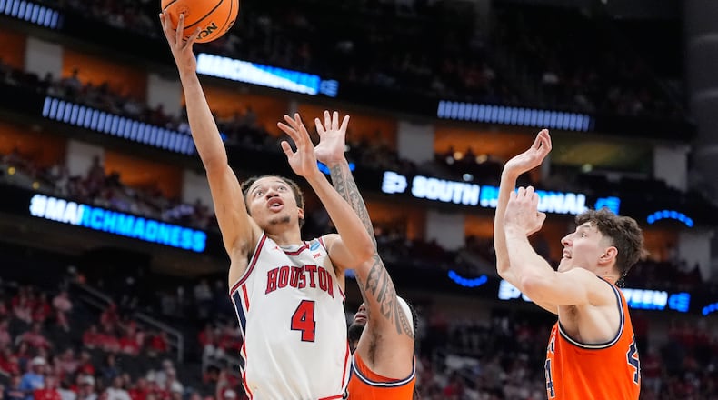 Houston guard Kingston Flemings (4) shoots past Illinois guard Kylan Boswell, center, and center Zvonimir Ivisic during the first half in the Sweet 16 of the NCAA college basketball tournament Thursday, March 26, 2026, in Houston. (AP Photo/Ashley Landis)