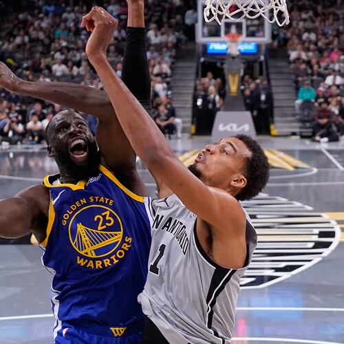 Golden State Warriors forward Draymond Green (23) drives to the basket against San Antonio Spurs forward Victor Wembanyama (1) during the second half of an NBA Cup basketball game in San Antonio, Friday, Nov. 14, 2025. (AP Photo/Eric Gay)