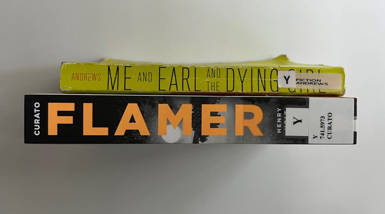 Two books — "Flamer" by Mike Curato and "Me and Earl and the Dying Girl" by Jesse Andrews — were removed from school libraries in Cobb County. The books in this photo were checked out from the Atlanta-Fulton Public Library.