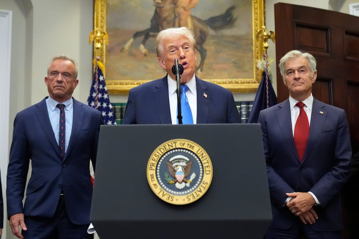President Donald Trump speaks inside the Roosevelt Room of the White House on Monday, Sept. 22, 2025, in Washington, D.C., as Health and Human Services Secretary Robert F. Kennedy Jr. (left) and Centers for Medicare and Medicaid Services administrator Dr. Mehmet Oz listen. (Mark Schiefelbein/AP)
