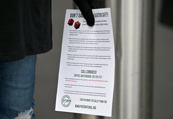 Daphne Hosea, union member of PASS, holds a flyer at Hartsfield-Jackson Atlanta International Airport's domestic terminal, Wednesday, October 29, 2025, in Atlanta. (Hyosub Shin/AJC)