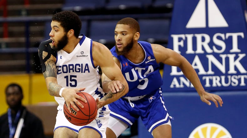 Georgia State guard D'Marcus Simonds (23) is defended by Texas-Arlington guard Edric Dennis (5) during the first half of the NCAA college basketball championship game of the Sun Belt Conference men's tournament in in New Orleans, Sunday, March 17, 2019. (AP Photo/Tyler Kaufman)