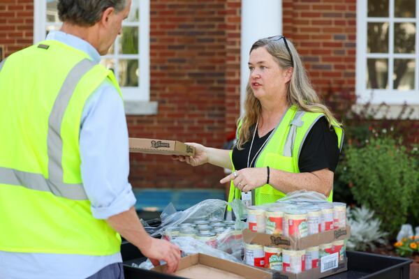Megan Rubio, the food pantry coordinator, talks with a volunteer. (Jason Getz/AJC)