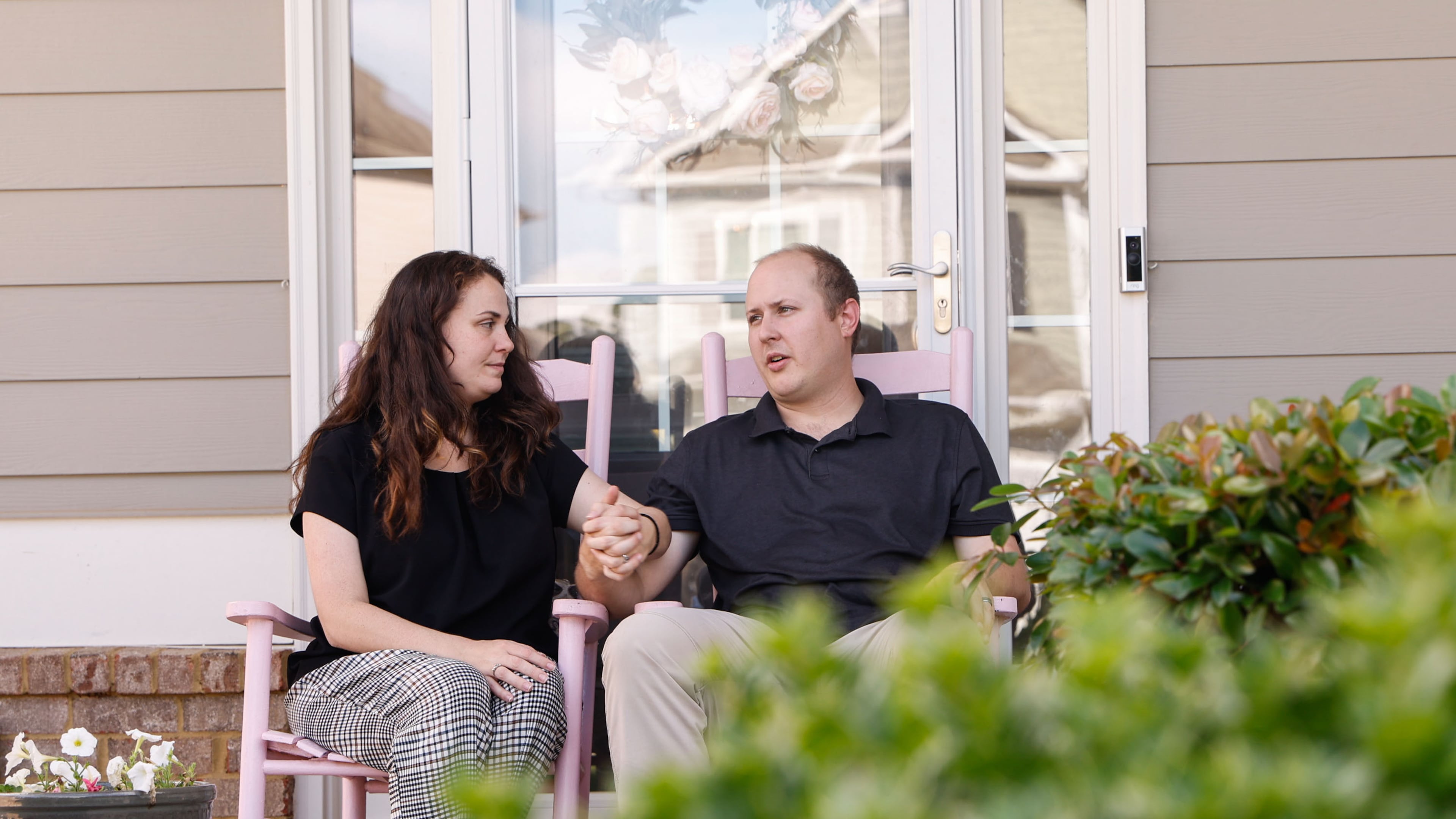 Stephen and Anslie Spitler sit on the front porch of their home in Hoschton, Ga. on Monday, May 12, 2025. (Natrice Miller/ AJC)
