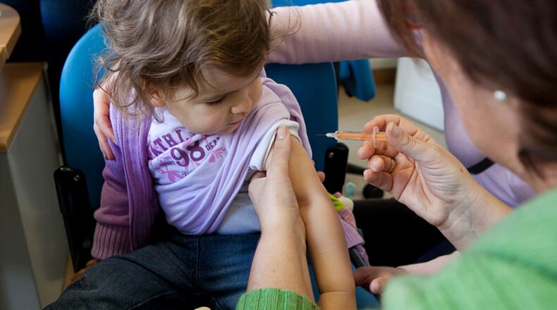 A child receives a flu shot. A new CDC study finds vaccines help prevent flu deaths among children.