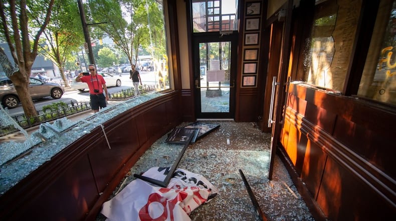 People stop to take photographs of the damage near the CNN Center after the George Floyd protest Saturday, May 30, 2020. STEVE SCHAEFER FOR THE ATLANTA JOURNAL-CONSTITUTION