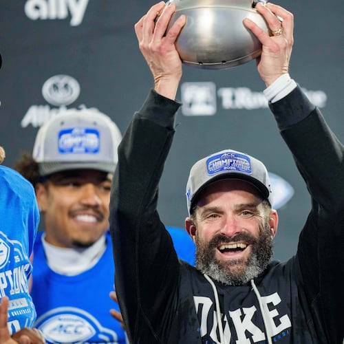 Duke head coach Manny Diaz holds up the trophy after defeating Virginia in the Atlantic Coast Conference championship NCAA college football game Saturday, Dec. 6, 2025, in Charlotte, N.C. (AP Photo/Jacob Kupferman)