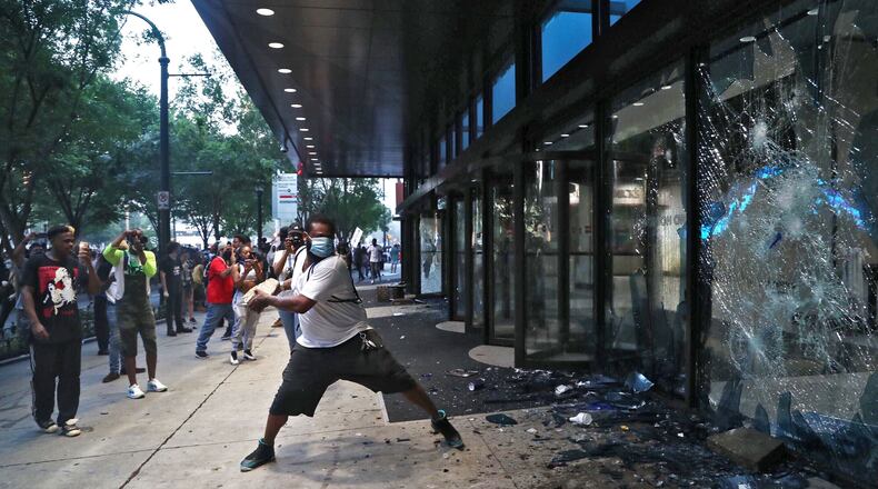 After a peaceful march the Capitol that swelled into the hundreds,  protesters returned to the area around the Centennial Olympic Park and CNN Center where some confronted police, who sprayed some demonstrators with pepper spray.  Later in the evening, protesters began breaking windows at area businesses. (Photo: Alyssa Pointer / alyssa.pointer@ajc.com)