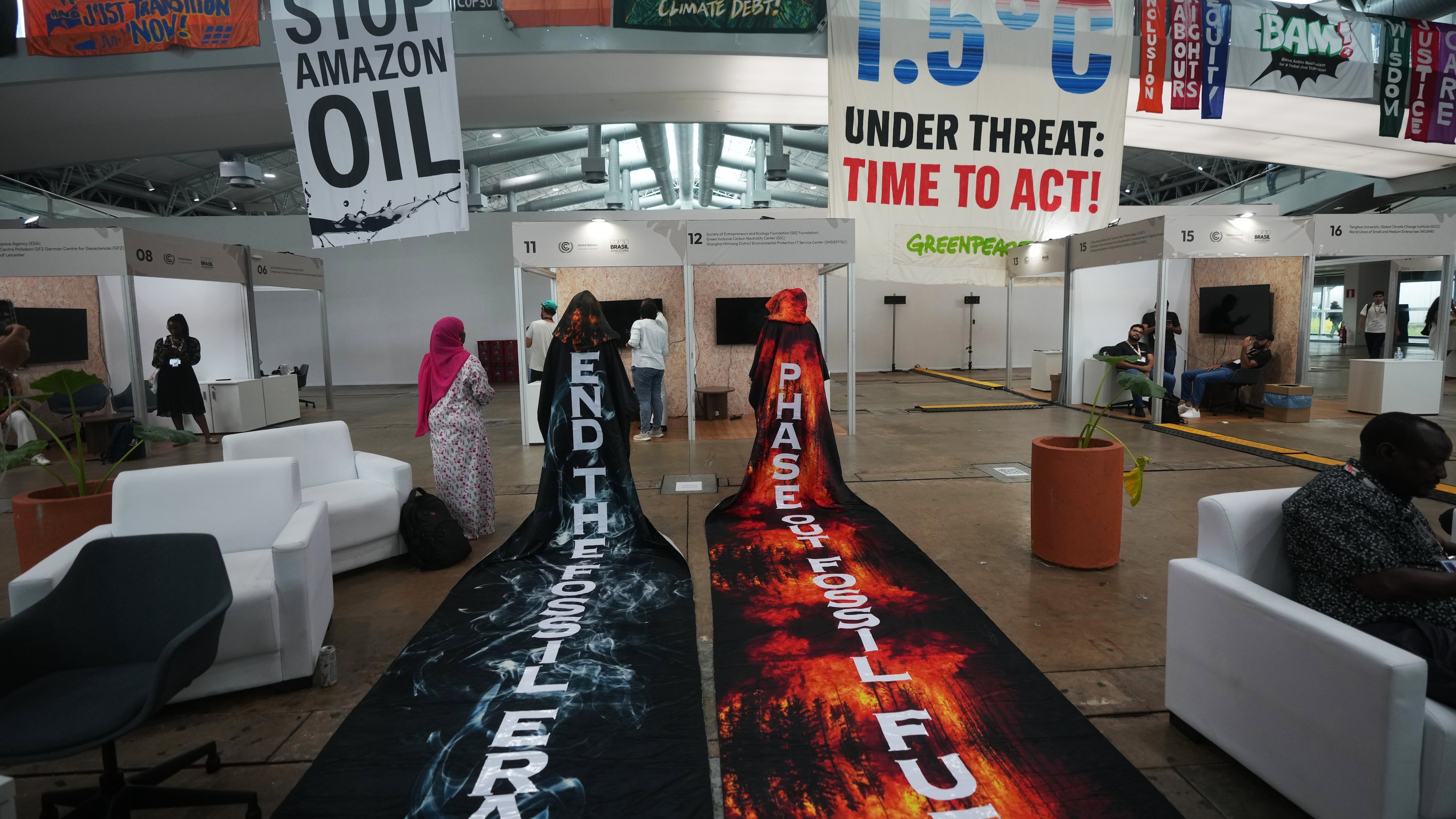 Activists hang banners while participating in a demonstration at the COP30 U.N. Climate Summit, Friday, Nov. 21, 2025, in Belem, Brazil. (AP Photo/Andre Penner)
