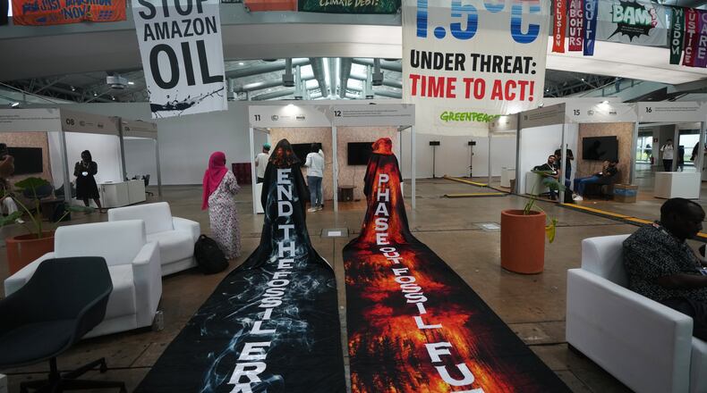 Activists hang banners while participating in a demonstration at the COP30 U.N. Climate Summit, Friday, Nov. 21, 2025, in Belem, Brazil. (AP Photo/Andre Penner)