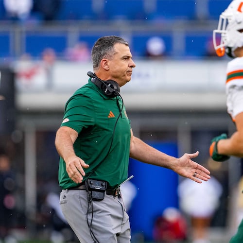 Miami head coach Mario Cristobal greets players as they come off the field during the first half of an NCAA college football game against SMU, Saturday, Nov. 1, 2025, in Dallas. (AP Photo/Jeffrey McWhorter)