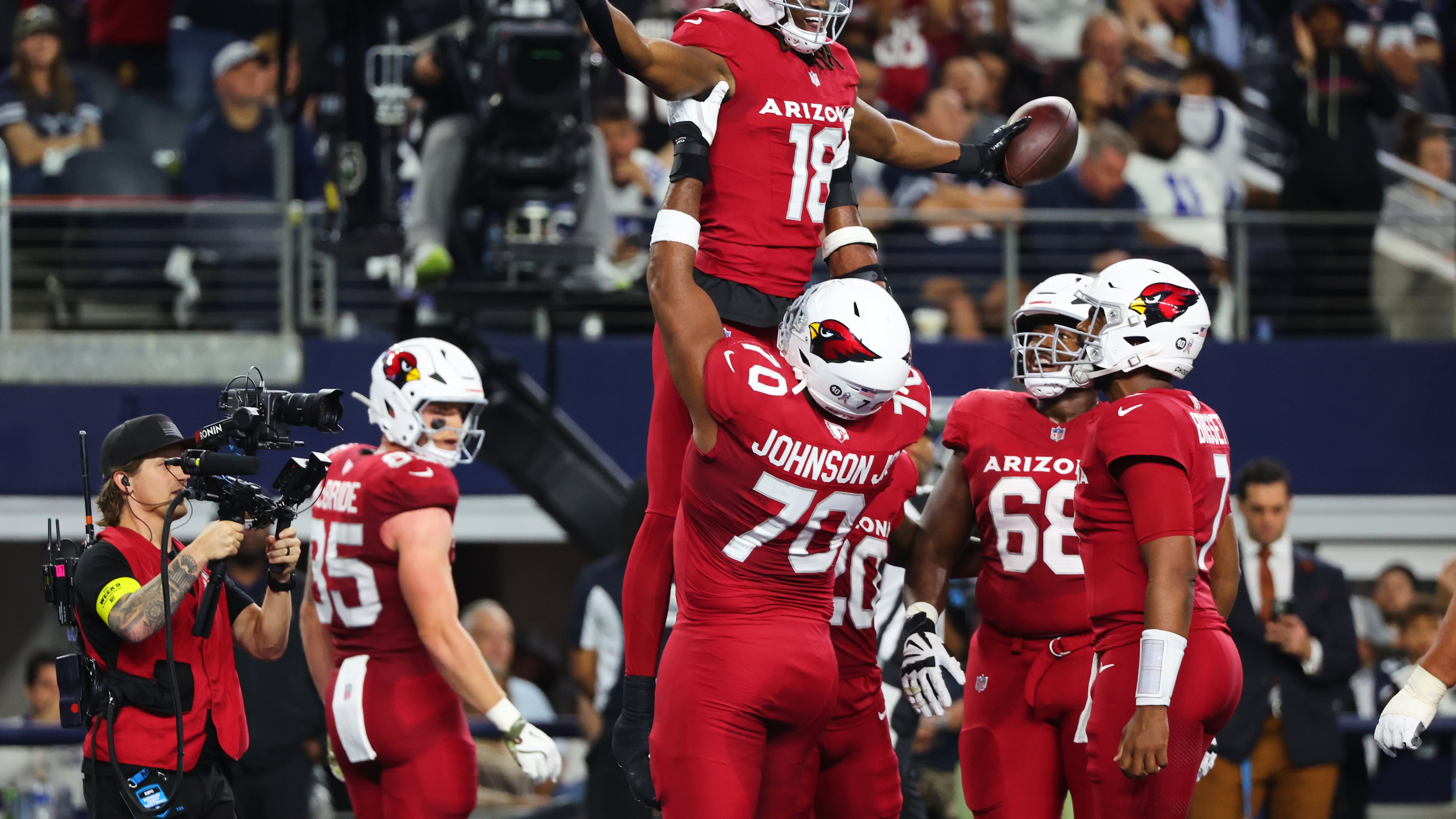 Arizona Cardinals wide receiver Marvin Harrison Jr. (18) is lifted by Paris Johnson Jr. (70) as the two and others celebrate Harrison Jr.s' touchdown catch in the first half of an NFL football game against the Dallas Cowboys Monday, Nov. 3, 2025, in Arlington, Texas. (AP Photo/Richard Rodriguez)
