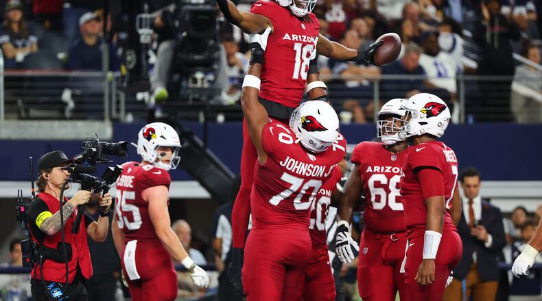 Arizona Cardinals wide receiver Marvin Harrison Jr. (18) is lifted by Paris Johnson Jr. (70) as the two and others celebrate Harrison Jr.s' touchdown catch in the first half of an NFL football game against the Dallas Cowboys Monday, Nov. 3, 2025, in Arlington, Texas. (AP Photo/Richard Rodriguez)