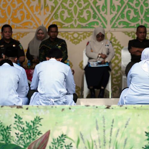 People convicted of violating Islamic law, among them are an unmarried couple who were found gulty of kissing during a TikTok livestream, wait for their turn to be publicly caned in Banda Aceh, Indonesia, Thursday, July 2, 2026. (AP Photo/Reza Saifullah)