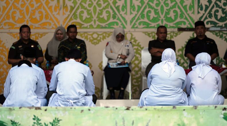 People convicted of violating Islamic law, among them are an unmarried couple who were found gulty of kissing during a TikTok livestream, wait for their turn to be publicly caned in Banda Aceh, Indonesia, Thursday, July 2, 2026. (AP Photo/Reza Saifullah)