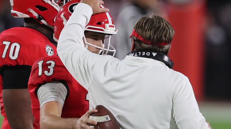 Georgia coach Kirby Smart gives QB Stetson Bennett a pat on the helmet during a moment on the sideline.