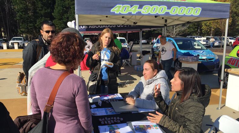 Affordable Care Act outreach specialist Liseth Fernandez and ACA navigator Viviana Cossio explain open enrollment to attendees at a festival last month at the Plaza Las Americas mall in Lilburn. The agency Georgia Refugee Health and Mental Health has set up ObamacareParaLatinos.org to target Latinos who need insurance, and HealthcareGA.org for others. This year GRHMH is Georgia’s only ACA navigator. (PHOTO by Ariel Hart / ahart@ajc.com)