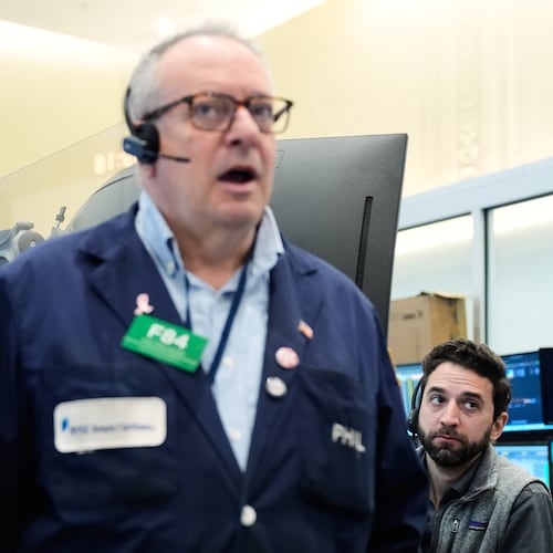 People work on the floor at the New York Stock Exchange in New York, Monday, April 13, 2026. (AP Photo/Seth Wenig)