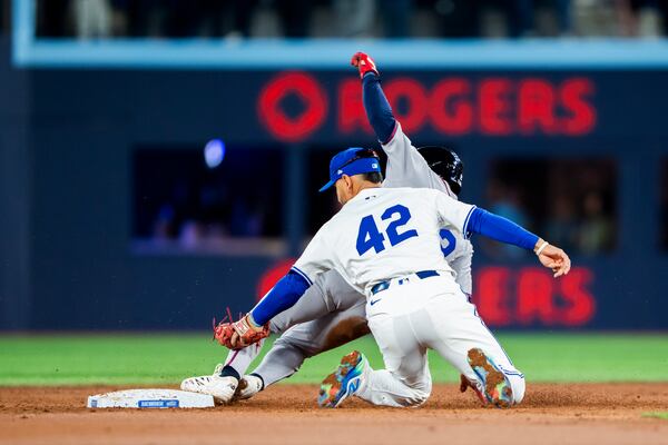 Atlanta Braves Nick Allen (back) is tagged out by Toronto Blue Jays Andres Gimenez during third inning MLB baseball action in Toronto on Tuesday April 15, 2025. (Thomas Skrlj/The Canadian Press via AP)