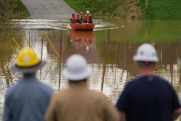 Pendleton County personnel use a boat to cross Max Goldberg Park after cutting power from a utility pole as the rising Licking River overflows its banks, Saturday, April 5, 2025, in Falmouth, Ky. (AP Photo/Carolyn Kaster)