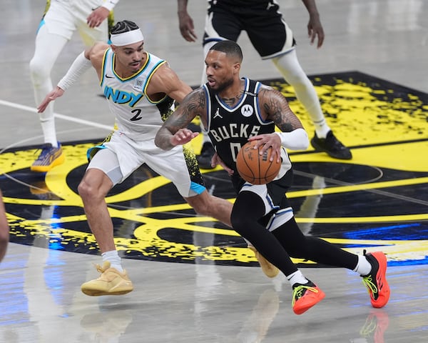 Milwaukee Bucks guard Damian Lillard (0) drives on Indiana Pacers guard Andrew Nembhard (2) during the first half of a first-round NBA basketball playoff game in Indianapolis, Tuesday, April 22, 2025. (AP Photo/Michael Conroy)