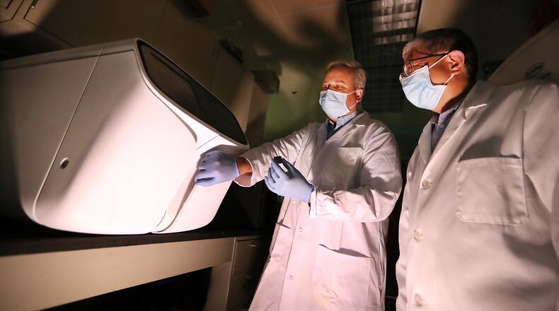 021121 Augusta: Project manager John Nechtman (left) and director Jin-Xiong She (right) work with a newly installed Ion Gene Studio S5 Prime Semiconductor Sequencer in the genomics core laboratory at Augusta University Medical Center on Thursday, Feb 11, 2021, in Augusta. The lab currently conducts genomic sequencing to study various illness, but has the capabilities to do the type of sequencing to identify variants of the virus.       Curtis Compton / Curtis.Compton@ajc.com”