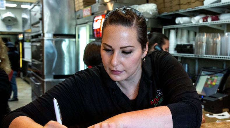 Joanna Fini takes an order while working the Friday night rush at Fini’s Pizzeria in Lawrenceville. STEVE SCHAEFER / SPECIAL TO THE AJC