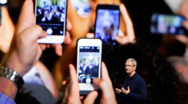 FILE - In this Wednesday, Sept. 7, 2016, file photo, Apple CEO Tim Cook announces the new iPhone 7 during an event to announce new products, in San Francisco. Apple reported Tuesday, Oct. 25, 2016, that it sold 45.5 million iPhones in the previous quarter, 5 percent fewer than it sold a year earlier. But the giant tech company's rosy forecast for the holidays was better than what Wall Street had been expecting. (AP Photo/Marcio Jose Sanchez, File)