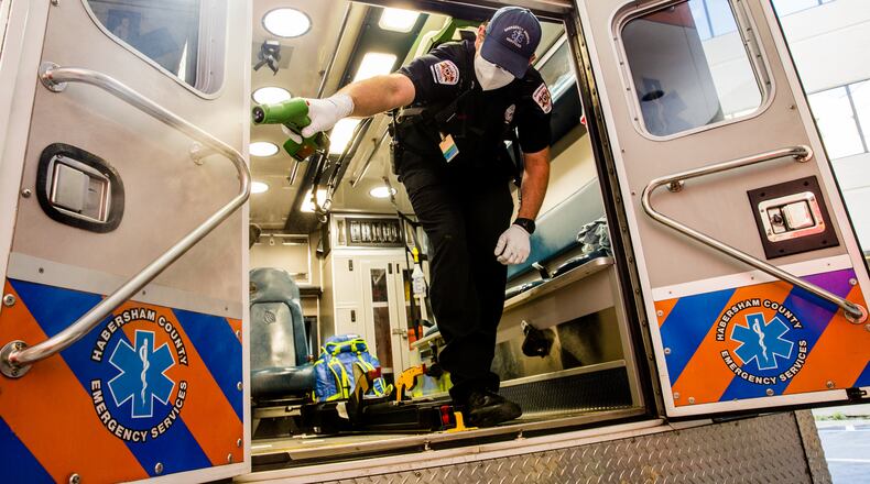 Jacob Palmer, an EMT with Habersham County Emergency Services, sanitizes an ambulance after dropping a patient in the emergency department at Northeast Georgia Medical Center. (Jenni Girtman for The Atlanta Journal Constitution)