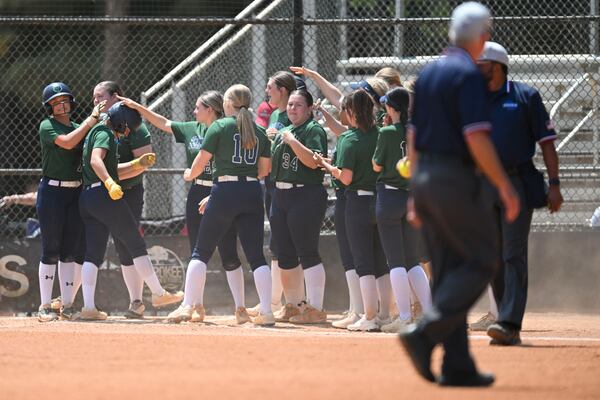 The Creekview Grizzlies celebrate with Loren Hodges as she crosses home plate during a GHSA championship slow-pitch softball game Thursday, April 23, 2026, in Woodstock. (Daniel Varnado for the AJC)