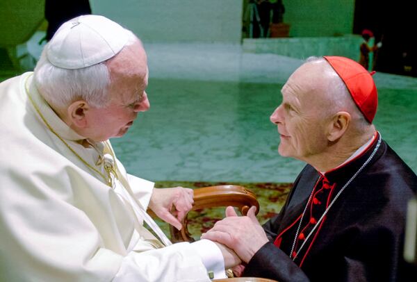 FILE - In this Feb. 23, 2001 file photo, U.S. Cardinal Theodore Edgar McCarrick, archbishop of Washington, D.C., shakes hands with Pope John Paul II during the General Audience with the newly appointed cardinals in the Paul VI hall at the Vatican. (AP Photo/Massimo Sambucetti, File)